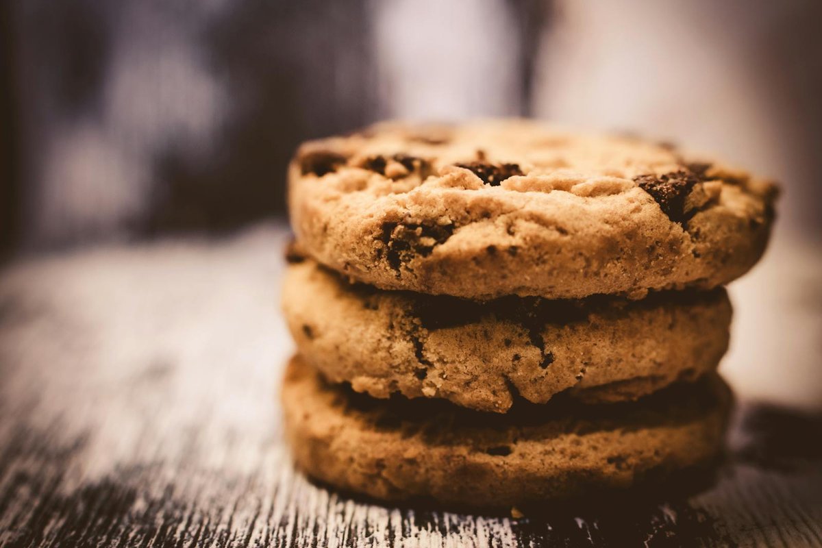 Cookies protéinés sans whey moelleux aux pépites de chocolat sur une planche en bois
